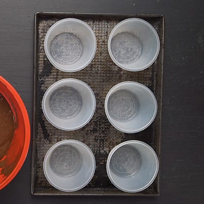 6 baking cups on a baking sheet
